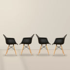 Four black Eames DAW dining armchairs with beech wood legs, illustrative studio set of 4